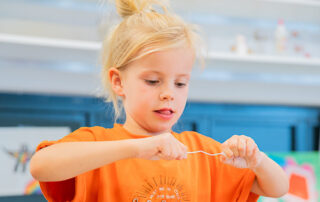 Meisje van de bso van kinderopvang huizen die mooi aan het knutselen is
