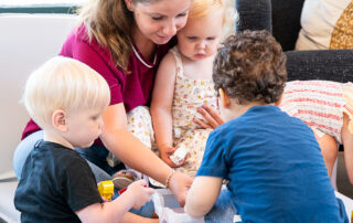 Een liefdevolle medewerker die met de peuters aan het spelen is op SKH kinderopvang huizen